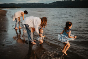 family of four playing by the water