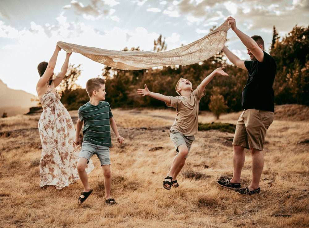 family of four playing games during family photo session
