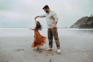 dad dances with daughter at cannon beach
