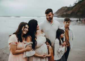 family of six posing for photos at cannon beach