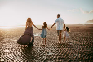 family of four walking at the beach during session with oregon coast family photographer