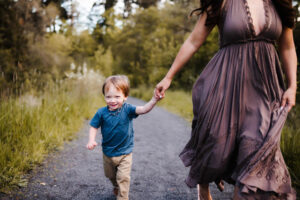 boy running at a park with is mom during photoshoot for beaverton toy stores