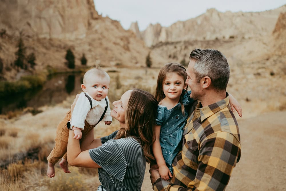 family cuddling and playing together at Smith Rock State park