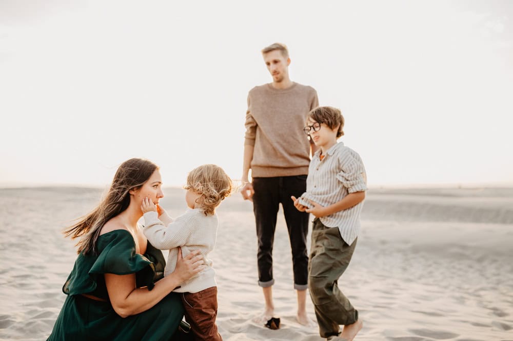 family of four play at the beach 