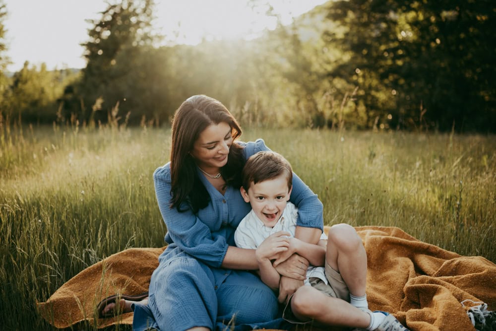 mother and son posing for photos at the park. moms wears a dress, a great example of what to wear for family photos