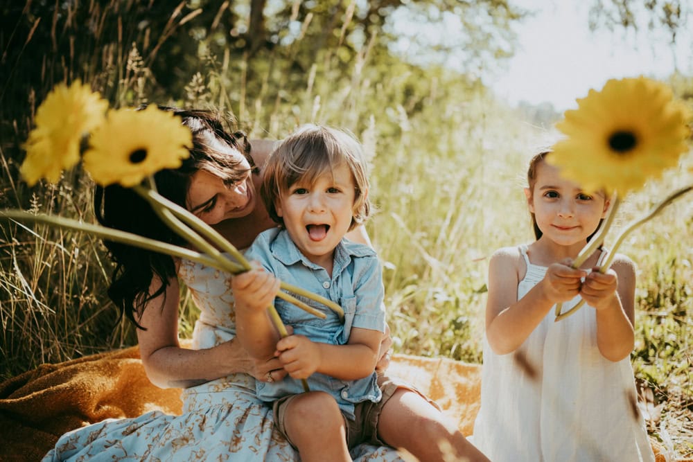 mother and her two kids playing with flowers