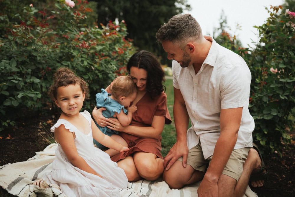family of four posing for photos at the international rose test garden